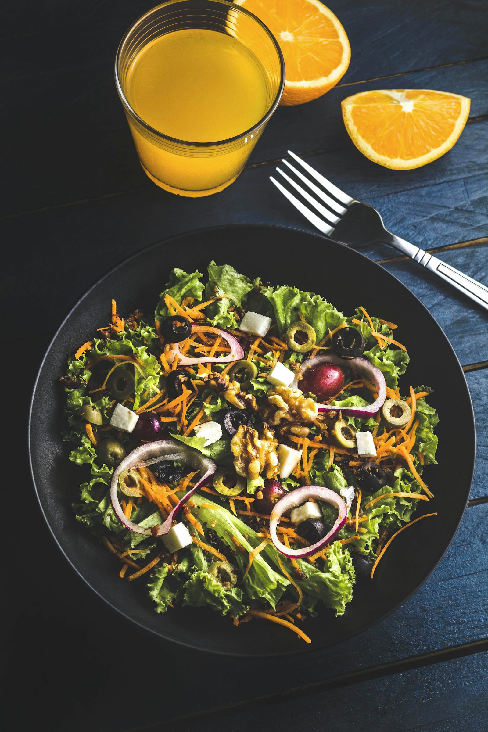 Leafy salad with red onion on a dark plate